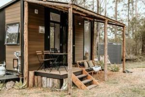 a small cabin with a porch and a table at Rosemont in Kempsey