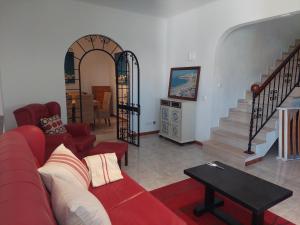 a living room with a red couch and stairs at Villa Lucia, Olhos D'Agua, Albufeira in Albufeira