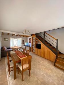 sala de estar con mesa de comedor y escalera en Hermosa Casa Familar de Montaña en San Carlos de Bariloche
