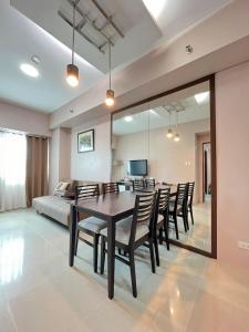 a dining room with a table and chairs and a bed at The Beacon Condo (1BR Unit) in Manila