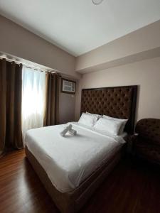 a bedroom with a large bed and a chair at The Beacon Condo (1BR Unit) in Manila