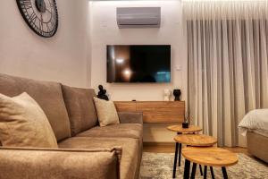 un soggiorno con divano e TV di Harmony Center Luxury Apartment a Komotini