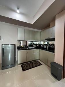 a kitchen with white cabinets and a stainless steel refrigerator at The Beacon Condo (1BR Unit) in Manila