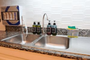 a kitchen sink with three bottles of wine at Makati Altean Apartment (Delfin Room) in Manila +29 photos