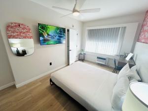 a bedroom with a white bed and a ceiling fan at Greenview Hotel By Lowkl in Miami Beach