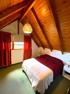 1 dormitorio con 1 cama en una habitación con techos de madera en Hermosa Casa Familar de Montaña en San Carlos de Bariloche