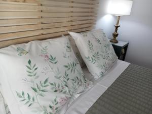 a bed with two pillows and a butterfly on it at Apartamento Turístico Damajuana in Espartinas