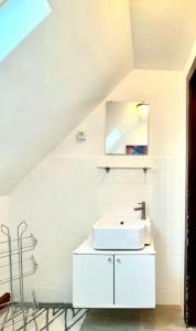 uma casa de banho branca com um lavatório e um espelho em Ferienwohnung in Hürth bei Köln em Hürth