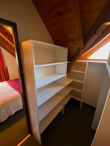 Habitación con cama y armario con estanterías. en Hermosa Casa Familar de Montaña en San Carlos de Bariloche