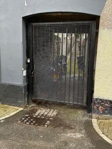a black gate in the side of a building at Studio Flat Twin - Town Centre in Merthyr Tydfil