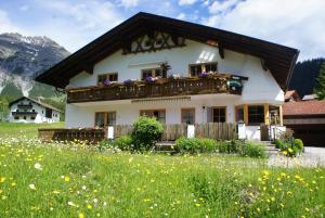a house with a balcony in a field of flowers at Sonnenbichl in Berwang