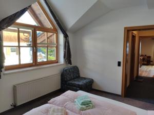 a bedroom with a bed and a chair and a window at Sonnenbichl in Berwang