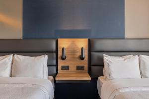 a room with two beds and a night stand between them at Fiesta Inn Mazatlán in Mazatlán