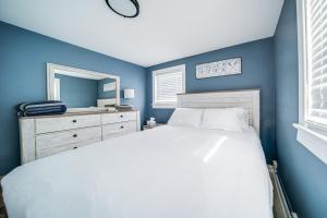 Dormitorio azul con cama y espejo en Jamestown Lake House with Boat Dock Access and Views!, en Jamestown