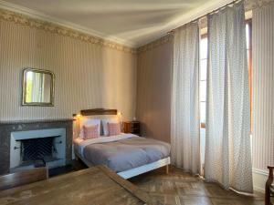 een slaapkamer met een bed, een open haard en een raam bij Château les Tours 300m², vue panoramique in Ayse