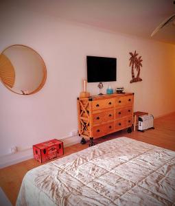 1 dormitorio con TV y tocador con espejo en Le Bali, en La Seyne-sur-Mer