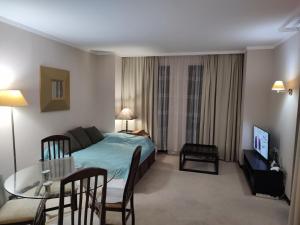 ein Schlafzimmer mit einem Bett und einem Tisch sowie ein Esszimmer in der Unterkunft Arendo Sea апартамент в Barceló in Sonnenstrand