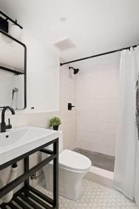 Baño blanco con aseo y lavamanos en Cozy, Large and Fully Furnished - Near the L Train en Brooklyn