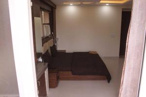 um quarto com uma cama num quarto com uma janela em OYO Hotel Daffodils Near Aravali Biodiversity Park em Gurgaon