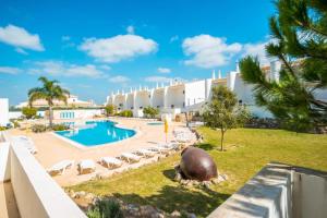 a view of a resort with a pool and lounge chairs at Aldeamento Turistico Aldeia da Galé in Albufeira