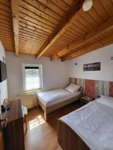 um quarto com 2 camas e um tecto de madeira em Pension & Ferienwohnungen Richter em Gerwisch
