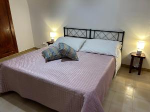 um quarto com uma cama grande com duas almofadas em L'Appartement dans les Venelles em Cefalù