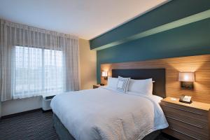 TownePlace Suites by Marriott Des Moines West/Jordan Creek في ويست دي موينز: غرفة فندقية بسرير كبير ونافذة