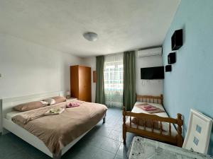 a hotel room with two beds and a television at Maki Apartments - Plavi Horizonti Beach in Tivat