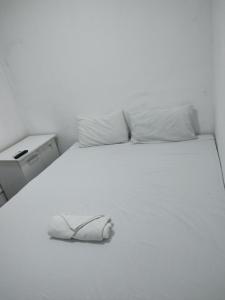 a white bed with a shoe on top of it at Pousada Belo Mar in Salvador