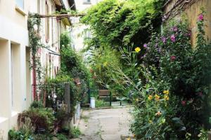 an alley with flowers and plants next to a building at Charming Paris Hideaway in Paris