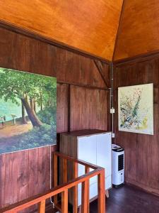 eine Küche mit einem Kühlschrank und ein Wandgemälde in der Unterkunft Karyasari kabin - Tiny House in Blimbing