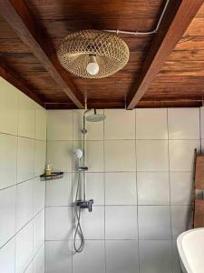 ein Bad mit einer Dusche und einer Decke in der Unterkunft Karyasari kabin - Tiny House in Blimbing
