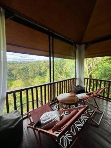 Zimmer mit einem Balkon mit Tisch und Stühlen in der Unterkunft Karyasari kabin - Tiny House in Blimbing
