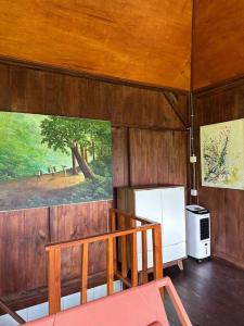 ein Zimmer mit einer Treppe und einem Gemälde an der Wand in der Unterkunft Karyasari kabin - Tiny House in Blimbing