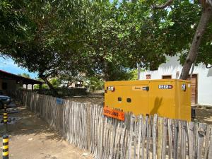 Una cerca con un objeto amarillo encima. en Casas Capulana, en Icaraí