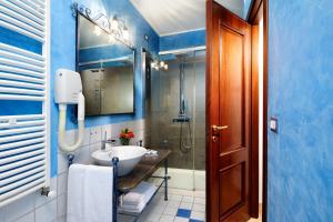 a blue bathroom with a sink and a shower at Kallikoros Country Resort & Spa in Noto