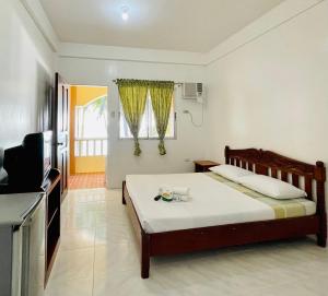 sypialnia z łóżkiem i telewizorem w pokoju w obiekcie LA FIESTA RESORT w mieście Boracay