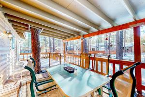 um quarto com uma mesa e cadeiras numa varanda em Dam Fun Cabin em Pinetop-Lakeside
