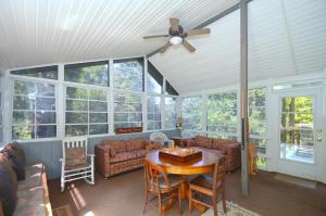 a living room with a ceiling fan and a table at Serendipity -- Hot Tub - Pet Friendly - Fire Pit - Grill - Porch - Deck - Wifi - Pool Access - Games in Berkeley Springs