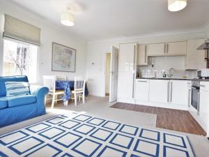 a living room with a blue couch and a kitchen at 2 Bed in Swanage DC192 in Swanage