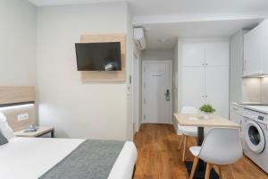 ein Schlafzimmer mit einem Bett und einem Schreibtisch sowie eine Küche in der Unterkunft Alda Palencia Catedral in Palencia