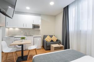 a bedroom with a bed and a table and a kitchen at InsideHome Palencia Catedral in Palencia