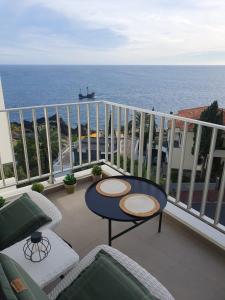 balcón con mesa, sillas y vistas al océano en Apartamentos do Mar - Pikis Flat, en Funchal
