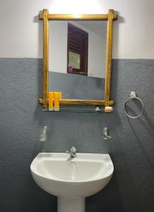 a bathroom with a white sink and a mirror at Seasons Four Mini Jungle Cabana in Matara