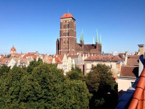 un grande edificio con una torre dell'orologio in una città di Black Swan House, Old Town a Danzica