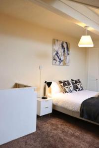 a bedroom with a bed and a lamp in it at Comfortable 2 Bedroom House in Beeston Hill