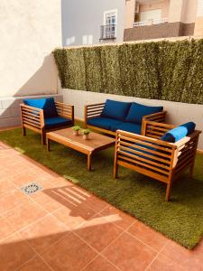 une terrasse avec deux bancs et un canapé bleu dans l'établissement La Vela, à Miramar