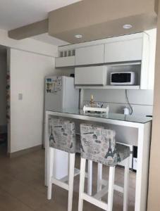 eine Küche mit einer weißen Theke und einem Kühlschrank in der Unterkunft DPTO FRENTE AL PARQUE FRANCISCO DE AGUIRRE in Santiago del Estero