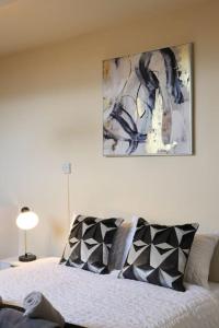 Beeston Hill的住宿－Comfortable 2 Bedroom House，卧室配有一张床,墙上挂有绘画作品