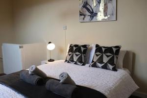 a bedroom with a bed with shoes on it at Comfortable 2 Bedroom House in Beeston Hill